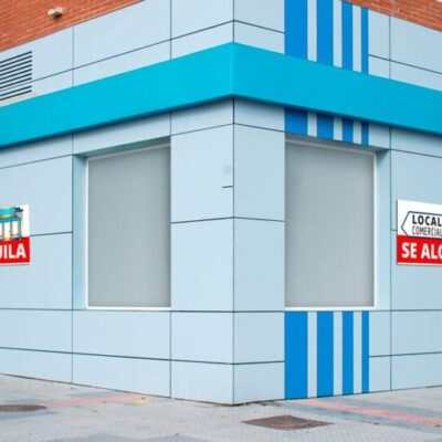 Local comercial de esquina en color azul con carteles de alquiler, ideal para ilustrar el servicio de arrendamiento de local de negocio de VAHUMAR – Asesoría PYB.