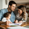 Familia con hija rellenando los papeles del complemento ayuda infancia 2025